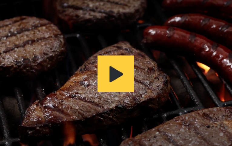 Video thumbnail depicting juicy steaks and sausages grilling on fiery barbecue grill.