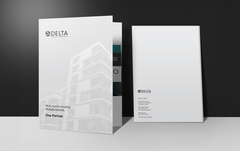 Two marketing brochures for delta property group, placed upright with a modern building design on the front cover, displayed against a soft gray background.