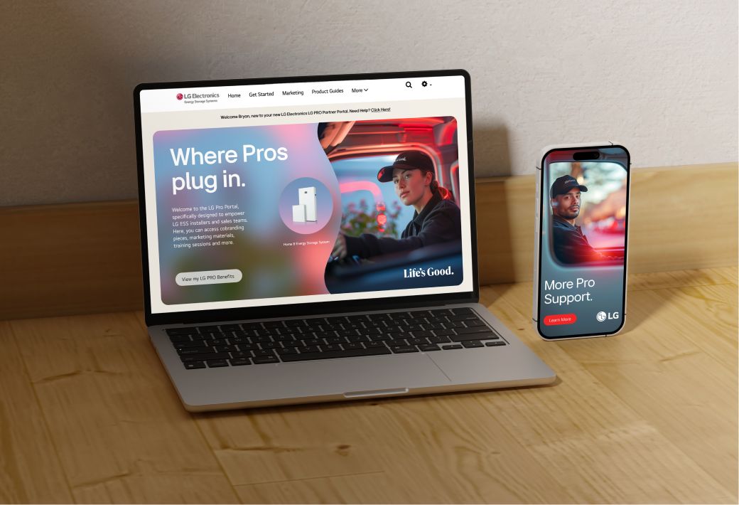 A laptop and smartphone on a wooden surface display LG electronics' website. The laptop shows a banner with the text "Where Pros Plug In" and an image of an LG product. The smartphone shows a similar banner with the text "More Pro Support.